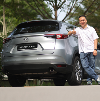Man leaning on a Mazda CX-8 outdoors
